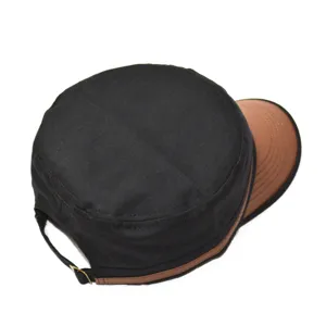 Vue détaillée de la casquette plate militaire en coton noir avec visière en cuir marron et boucle.