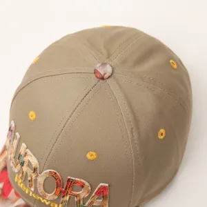 Close-up detail of the stylish embroidered letter baseball cap, showing fine texture.