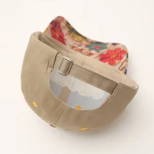 Women's casual baseball cap detail view, featuring beige hard top and colorful floral brim.