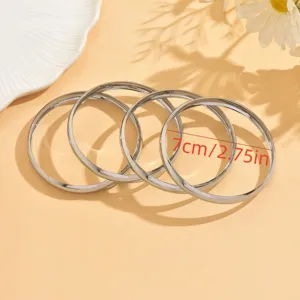 Détail de bracelet jonc rond et lisse en métal brillant avec une taille de sept centimètres.
