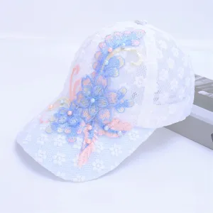 Detailed close-up of white lace baseball cap featuring exquisite floral embroidery and pearls.