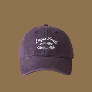 Close-up detail of the purple embroidered baseball cap with white cursive lettering.