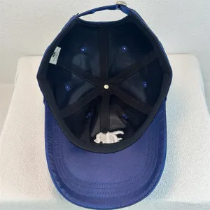 Detailed view of the dark blue satin baseball cap showing interior lining and construction.