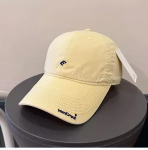 Close-up of a Korean style soft-top baseball cap with delicate embroidery and neutral tone.
