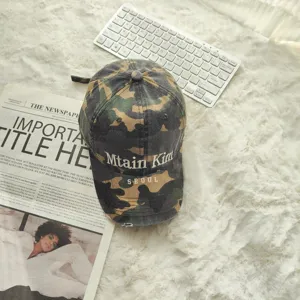 Nahaufnahme einer Retro-Camouflage-Baseballkappe mit Stickerei und abgenutztem Krempendetail.