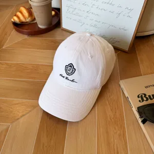 White embroidered baseball cap detail shot, stylish casual summer hat with classic logo.