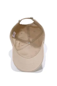 Inside detail view of a khaki cotton baseball cap showing internal stitching and wash label.
