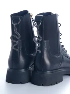 Detail view of black leather gothic Martin boots showcasing the metal snake pendant on the heel.