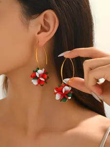 Detail shot of colorful acrylic flower earrings featuring red, white and green festive petals.