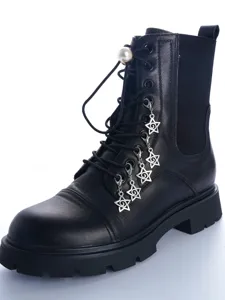 Close-up detail of black leather combat boots with metallic star pendants and pearl lace buckle.