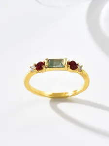 Close-up detail of vintage gold-plated copper ring with green and red stone inlay design.