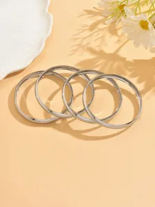 Vue détaillée de bracelets jonc ronds en métal argenté lisse, bijoux de poignet élégants.