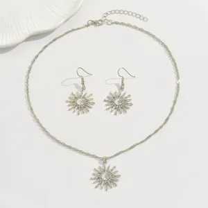 Close-up of alloy rhinestone sun moon pendant necklace earrings set on white background.