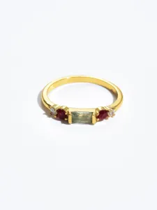 Close-up of gold-plated vintage geometric ring with green and red stones for women chic detail
