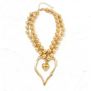 Gold layered beaded necklace with irregular oversized heart pendant detail for stylish women fashion.