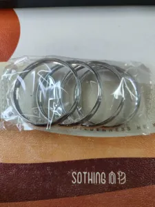 Ensemble de bracelets rigides en metal argente lisse, emballage plastique minimalist.