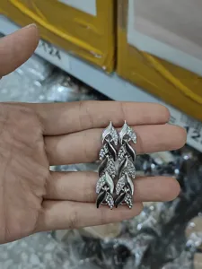 Detailed shot of luxury crystal leaf dangling earrings, rhinestone mermaid tail design for women.