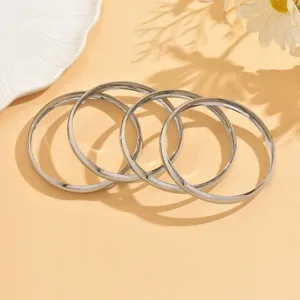 Ensemble de bracelets jonc ronds en métal argenté lisse, bijoux géométriques chics.