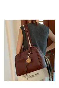 Detail view of retro large capacity women shoulder bag, minimalist dark red leather tote bag.