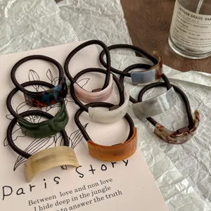 Detailed shot of Korean style geometric acetate hair ties with elegant curved design and ponytail.