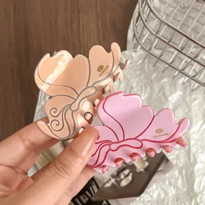 Detailed shot of elegant matte hair claw clip in pink and nude, stylish flower shape accessory.