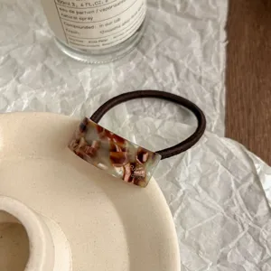 Detailed shot of the elegant vintage acetate geometric hair tie with brown elastic rope.