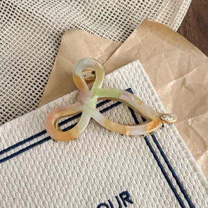 Acetate hair claw featuring a unique interlocking shape and colorful marble pattern for daily use.