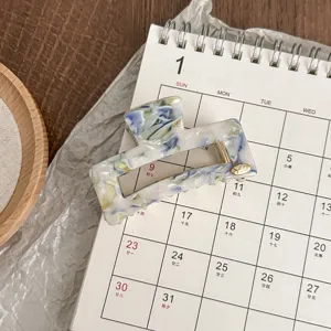 Detailed view of a small square acetate hair claw clip with retro oil painting blue pattern.