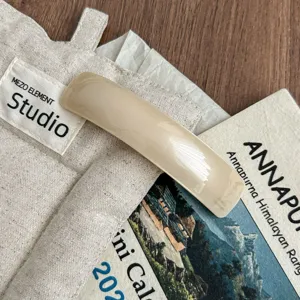 Minimalist beige acetate hair clip detail showing smooth curved design and spring barrette.
