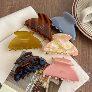Detailed close-up of medium acetate hair claw clips showcasing various elegant colors and textures.