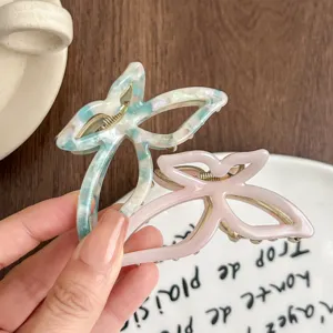 Vista detallada de pinza de pelo de mariposa en acetato, elegante pinza mediana para mujeres.