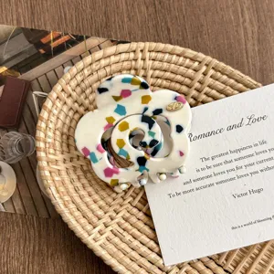 Close-up detail of the colorful terrazzo flower hair claw clip, elegant aesthetic display.