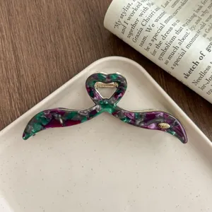 Detail view of the stylish irregular acetate hair claw clip with unique heart design.