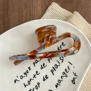 Detailed view of the retro tortoiseshell hair claw, elegant geometric fish tail design for women.