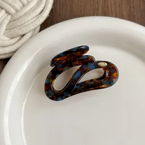 Tortoiseshell irregular hair claw clip for women, elegant acrylic shark clip detail view.