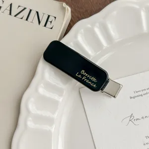 Elegant black acetate duckbill hair clip with gold lettering for women daily styling.