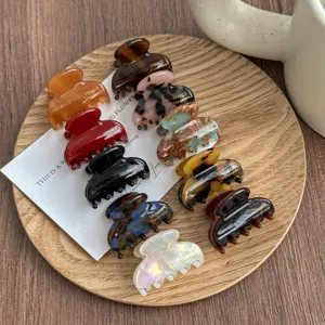 Detailed close-up of mini hair claw clips in assorted tortoise and pearl colors, elegant design.