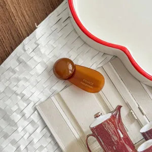 Detailed view of brown acetate round ball hair clip, elegant side bangs hair accessory for women.