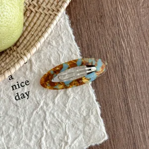 Detailed shot of Korean style oval acetate hair clip with blue tortoiseshell design.