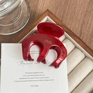 Detailed close-up of the red acetate hair claw clip, showing glossy finish and texture.