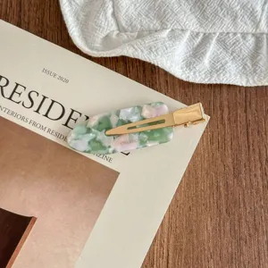 Elegant acetate hair clip with green marble pattern and gold metal clip, stylish side hairpin.