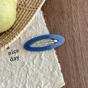 Detailed close-up of Korean style hollow oval acetate hair clip, elegant blue side clip.