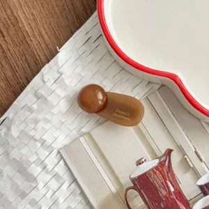 Detail view of brown round ball hair clip, elegant acetate side hairpin accessory.