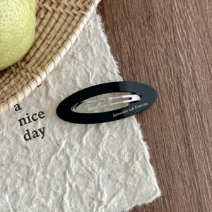 Korean style black oval acetate hair clip detail shot, elegant hollow design for women hair styling.