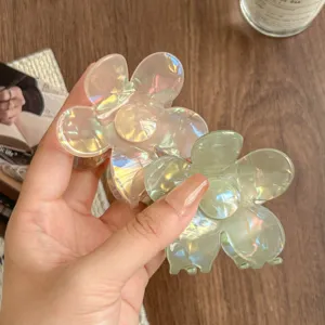 Close-up detail of iridescent flower hair claws showing glossy transparent resin texture.