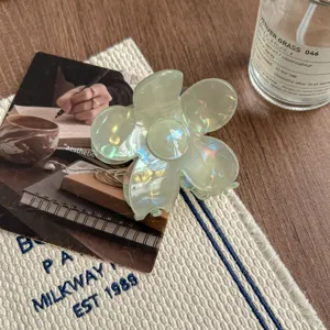 Transparent flower hair claw clip, light green iridescent resin shark clip detail view.
