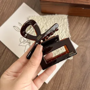 Detailed view of dark brown acetate hair claw clip with elegant handmade finish, perfect for styling.