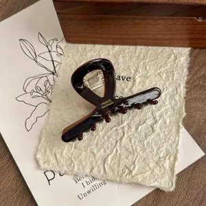 Close-up of elegant brown acetate hair claw clip, showcasing exquisite handmade texture and details.