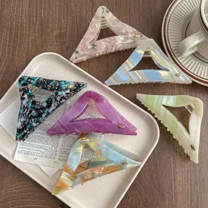 Detailed shot of retro acetate triangle hair claw, aesthetic aesthetic hairpin accessory for women.