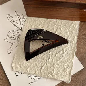 Detail shot of brown acetate hair claw clip, chic geometric triangle design for women daily hair styling.